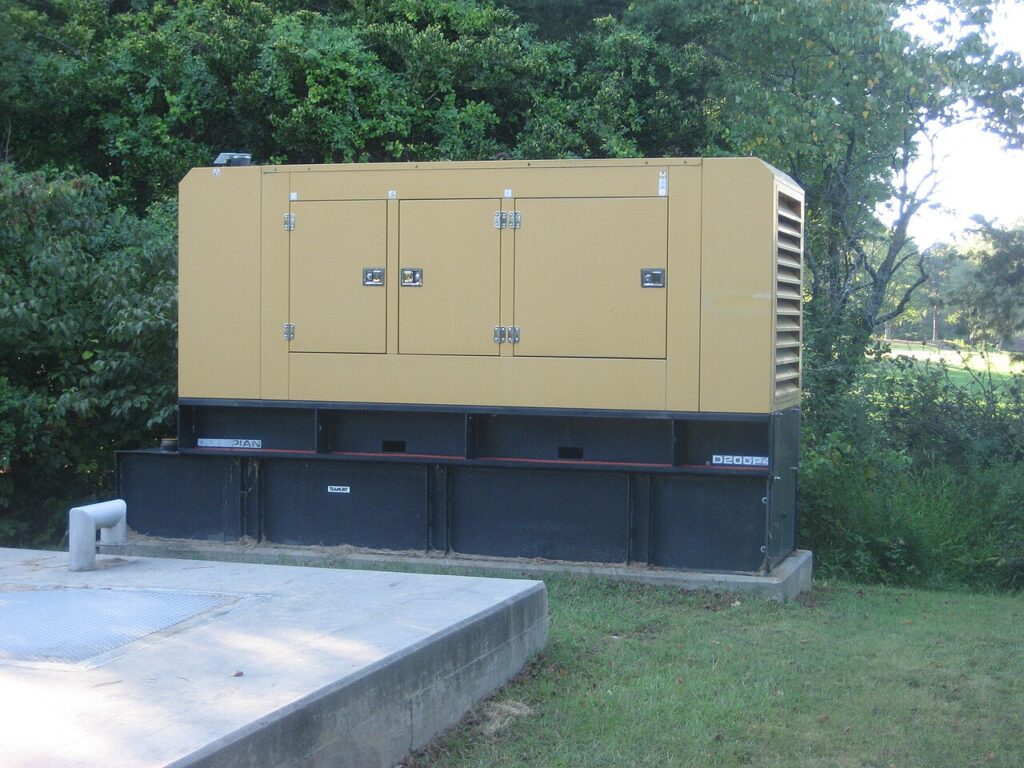 Yellow enclosed diesel generator set mounted on a plinth outdoors